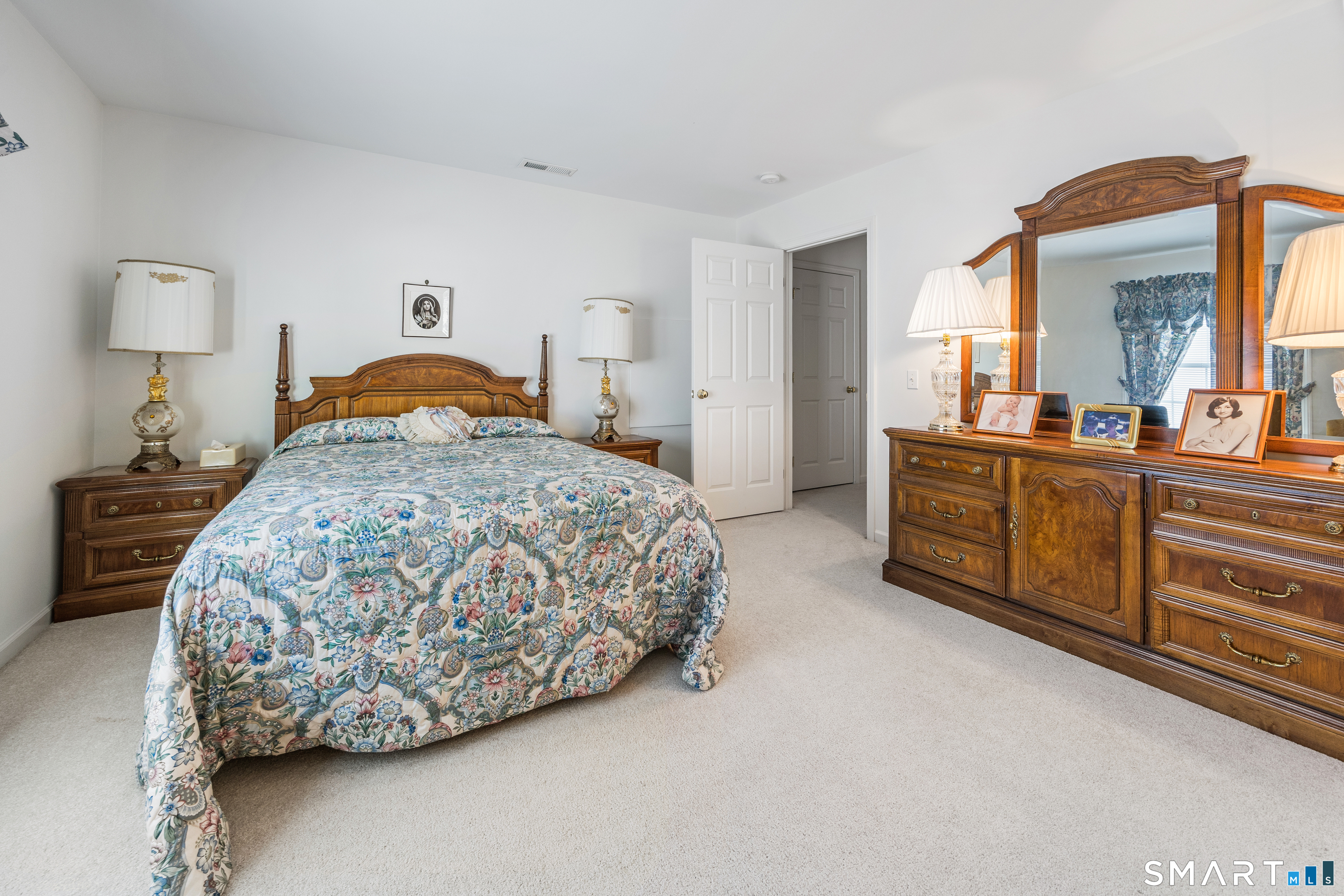 39 Phillips Farm Road, Unit 39 East Hartford, CT 06118 - Photo 22 of 32 a bedroom with a bed and dresser with mirror