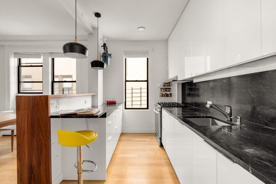 790 Riverside Drive, Unit 12K Manhattan, NY 10032 - Photo 4 of 11 a kitchen with stainless steel appliances granite countertop a sink a stove and a wooden floors