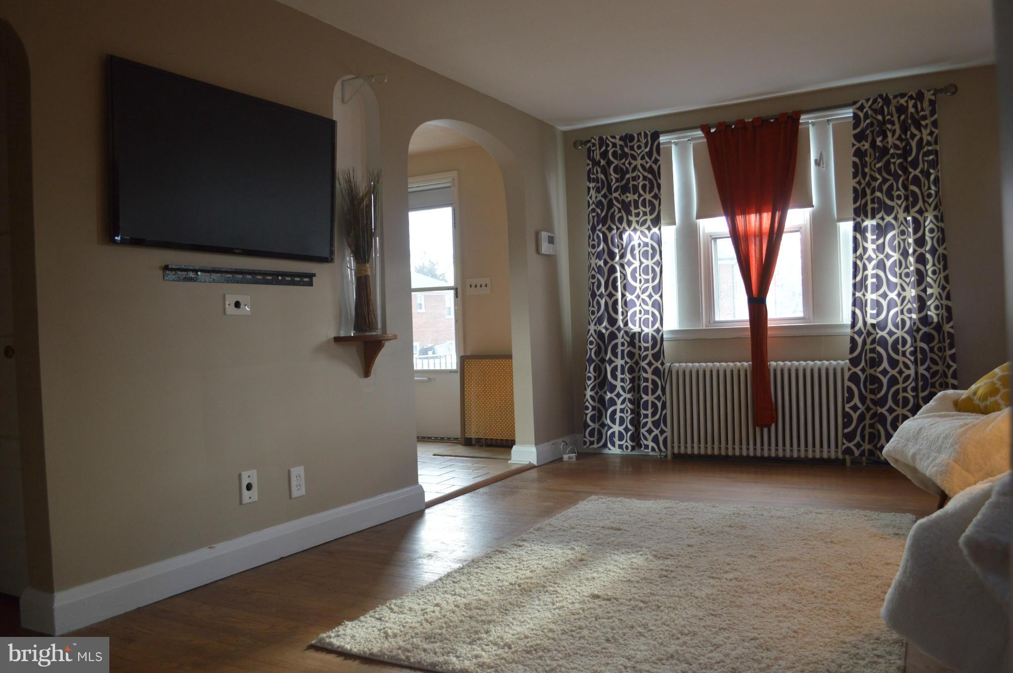 746 Charing Cross Road Baltimore, MD 21229 - Photo 4 of 30 a view of an empty room with a window and wooden floor