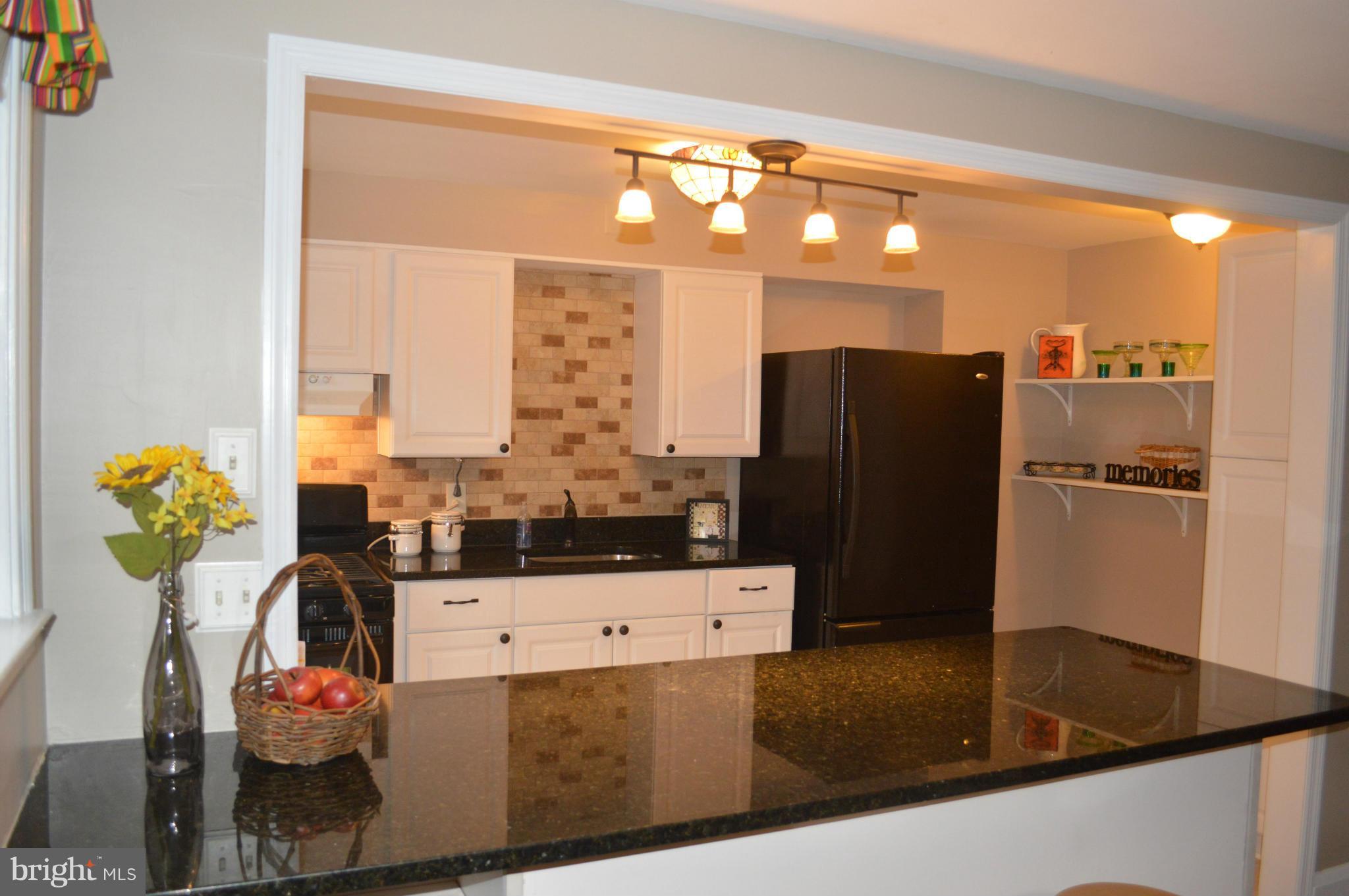 746 Charing Cross Road Baltimore, MD 21229 - Photo 9 of 30 a kitchen with stainless steel appliances kitchen island granite countertop a refrigerator and a stove