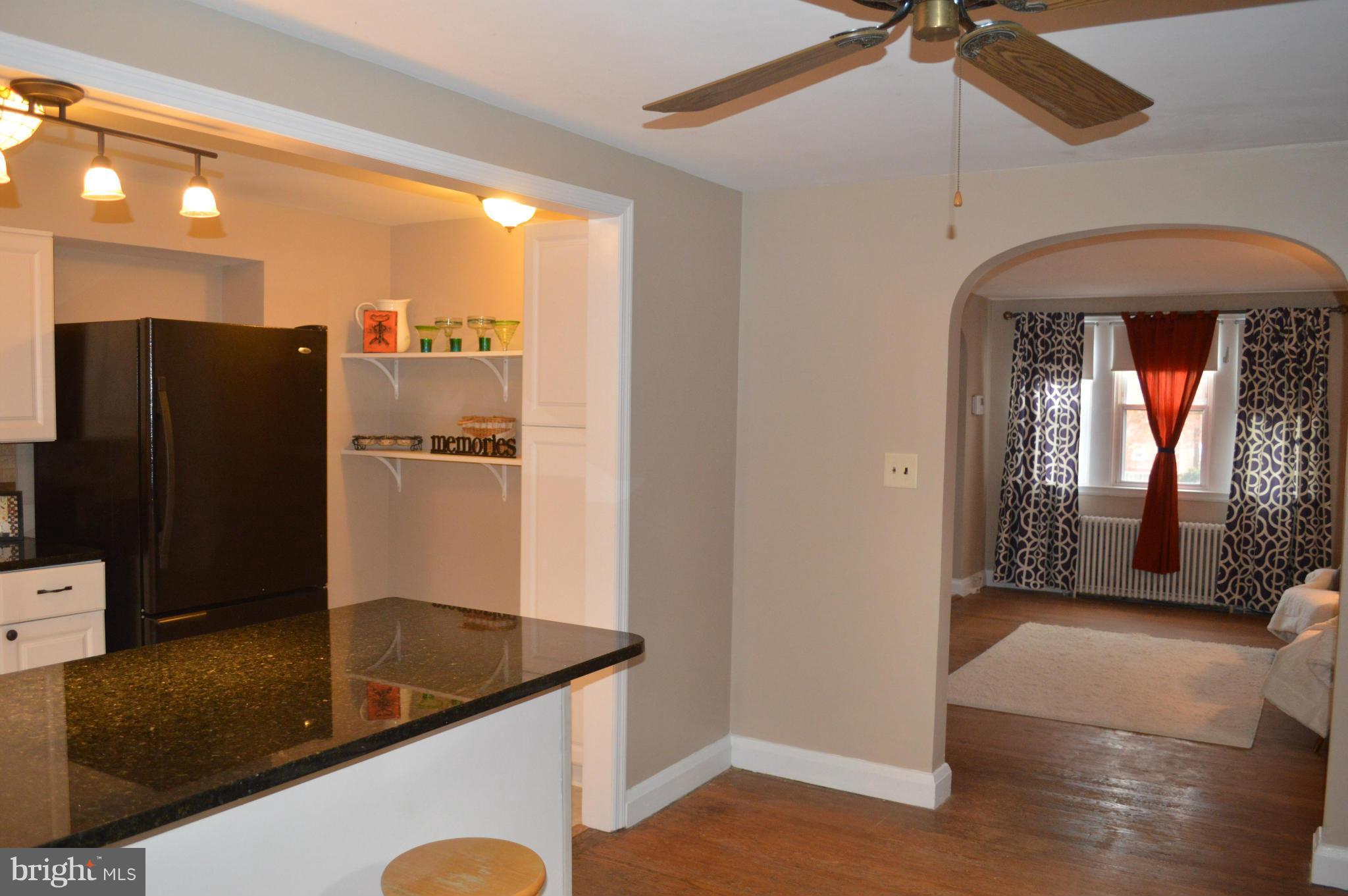 746 Charing Cross Road Baltimore, MD 21229 - Photo 10 of 30 a kitchen with stainless steel appliances granite countertop a refrigerator a oven and white cabinets with wooden floor