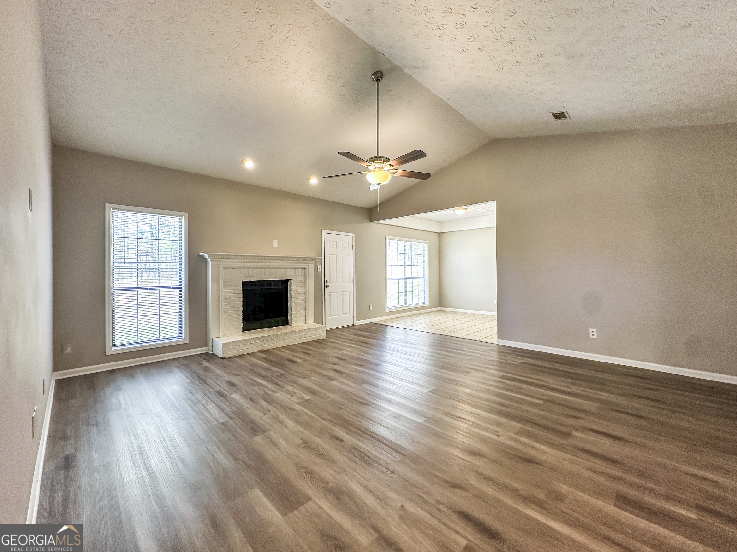 11647 Matthews Trail Hampton, GA 30228 - Photo 4 of 18 an empty room with wooden floor and windows