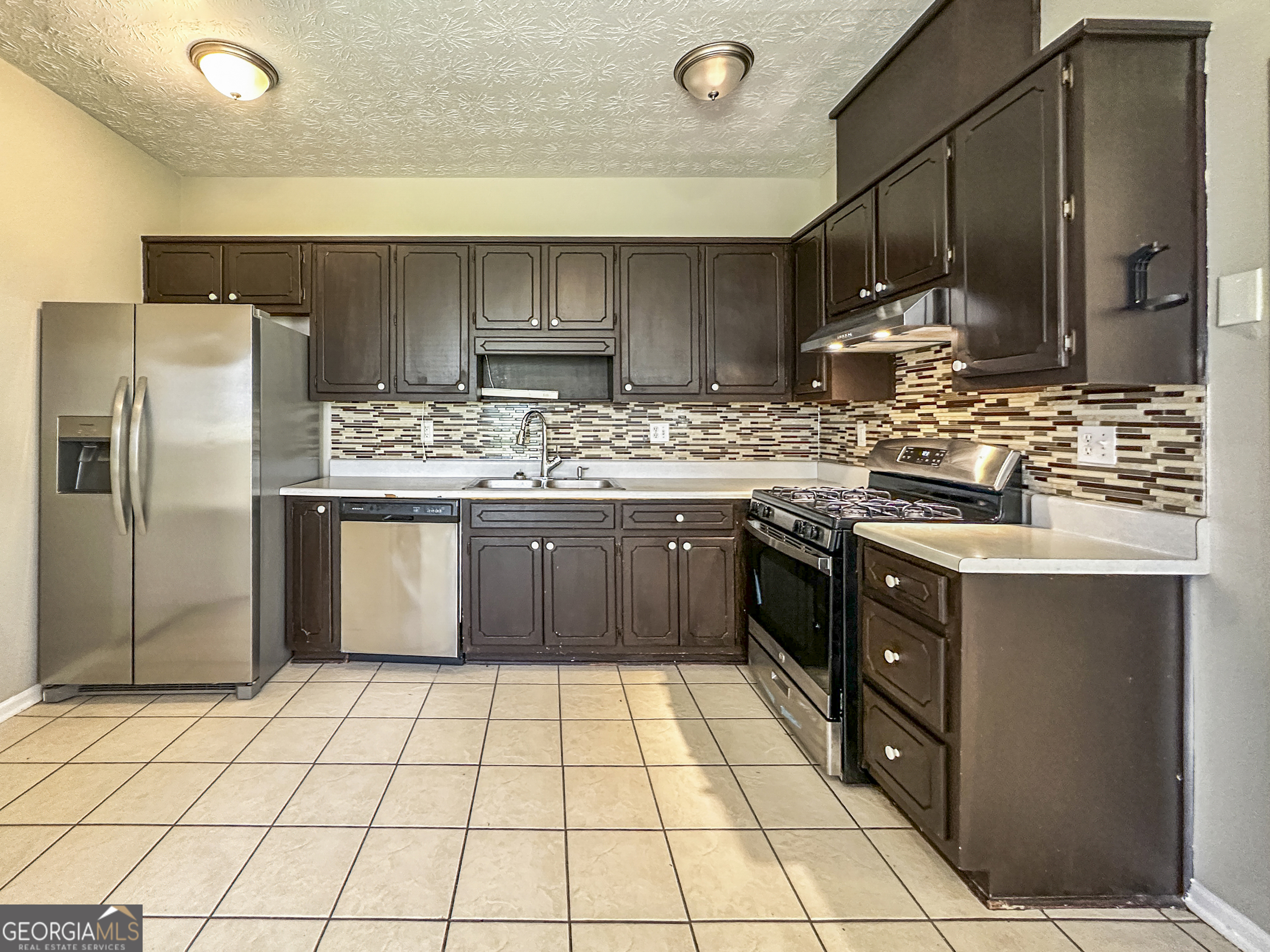 11647 Matthews Trail Hampton, GA 30228 - Photo 7 of 18 a kitchen with stainless steel appliances granite countertop a stove a sink and a refrigerator