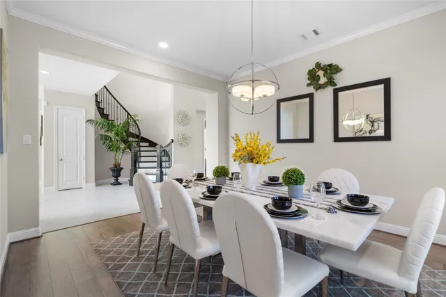a view of a dining room with furniture a chandelier and wooden floor