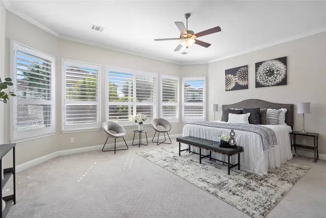 a spacious bedroom with a bed a couch and large windows