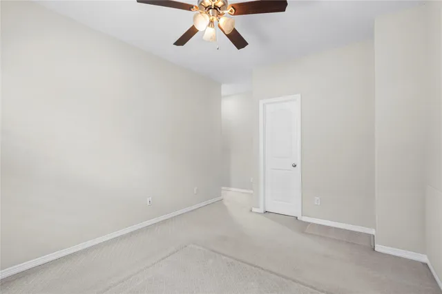 an empty room with a window and a ceiling fan