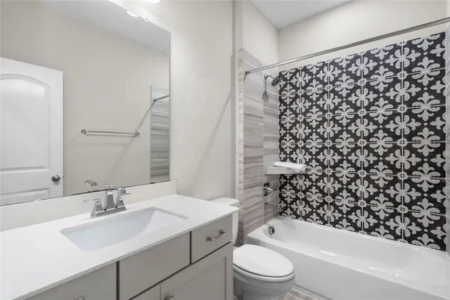 a bathroom with a bathtub sink vanity mirror and toilet