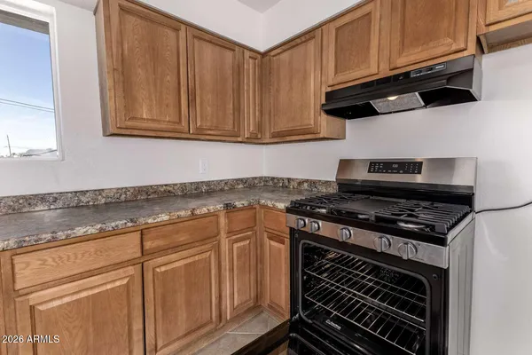 a kitchen with granite countertop a stove and cabinets