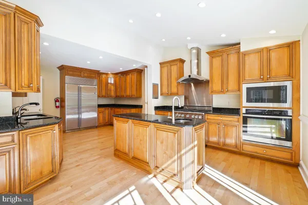 a kitchen with stainless steel appliances granite countertop a sink a stove and a refrigerator