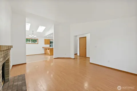 an empty room with a fireplace and wooden floor
