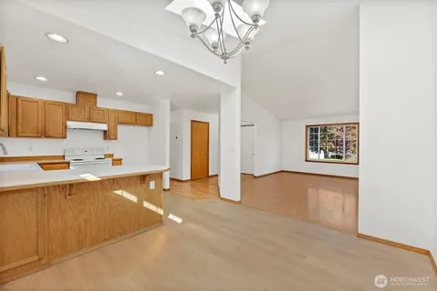 a large kitchen with stainless steel appliances a large counter top a stove and a refrigerator