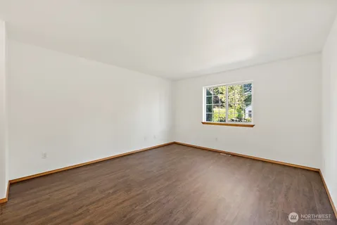 an empty room with wooden floor and window