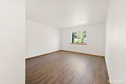 an empty room with wooden floor and window
