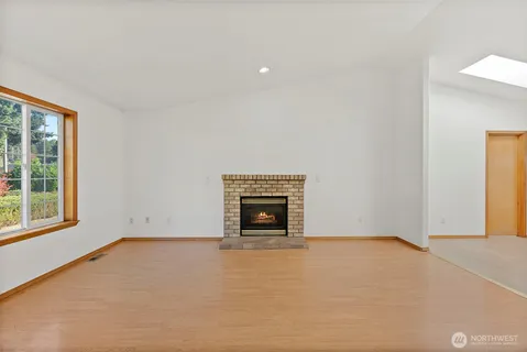 an empty room with a fireplace and window