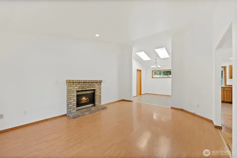 an empty room with windows and fireplace