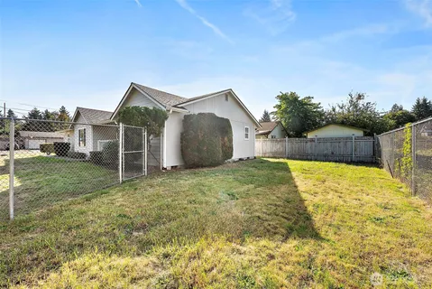 a view of a house with backyard and tree