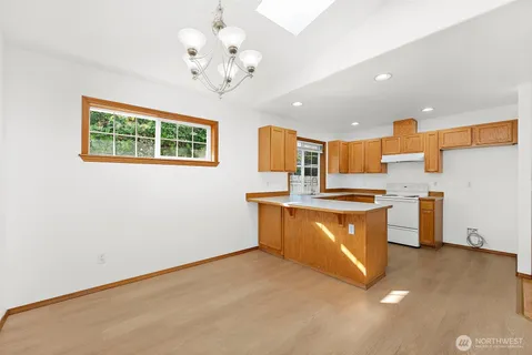 a large kitchen with stainless steel appliances granite countertop a stove and a sink with cabinets