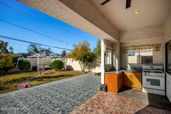 a view of a swimming pool with chairs in front of a house