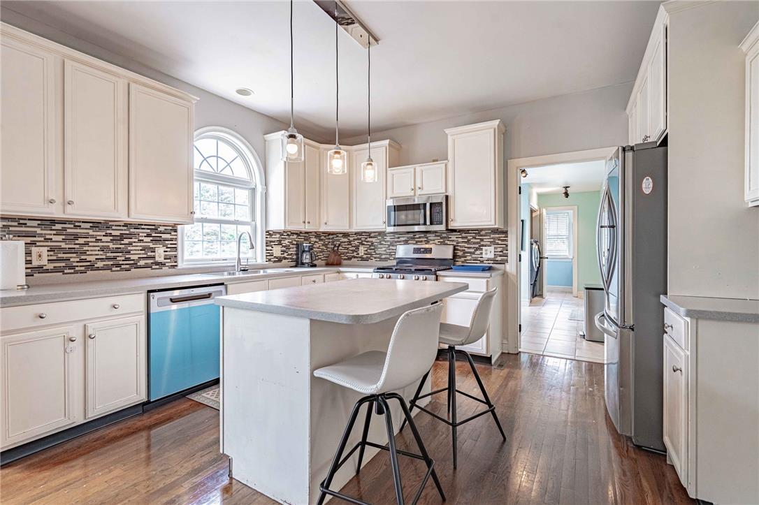 102 Sutton Road Easton, PA 18045 - Photo 23 of 83 Rich hardwood flooring anchors this bright kitchen featuring a center island and classic cabinetry.