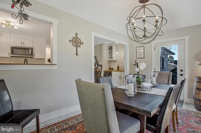 a view of a dining room with furniture a chandelier and wooden floor