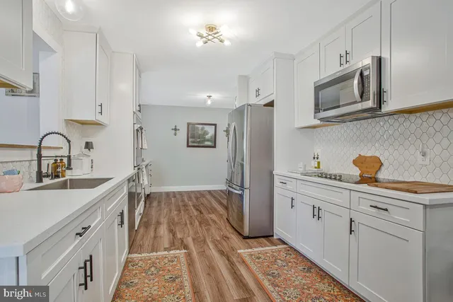 a kitchen with granite countertop a sink stainless steel appliances and cabinets