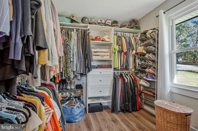 a view of walk in closet with clothes and shoes