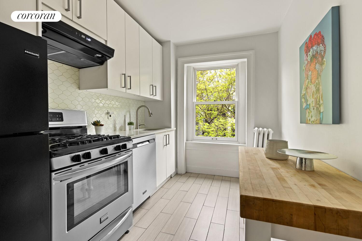 122 State Street Brooklyn, NY 11201 - Photo 21 of 26 a kitchen with stainless steel appliances a stove a sink and wooden cabinets
