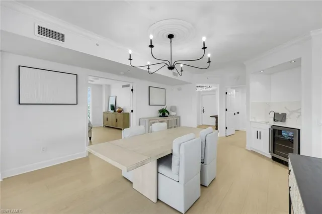 a living room with furniture a chandelier and a flat screen tv