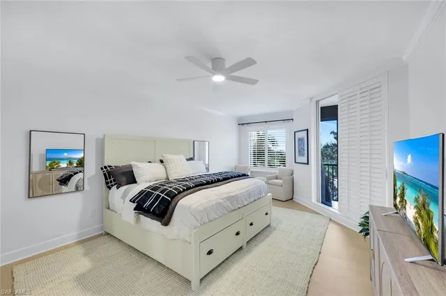 a bedroom with a bed and a flat tv screen on the dresser