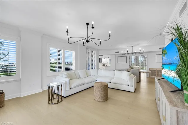 a living room with furniture and a chandelier
