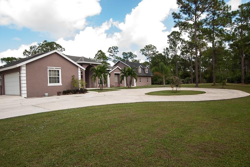 12557 154th Road North Jupiter, FL 33478 - Photo 33 of 38 a front view of a house with a yard and trees