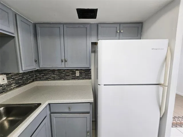 a white refrigerator freezer sitting inside of a kitchen