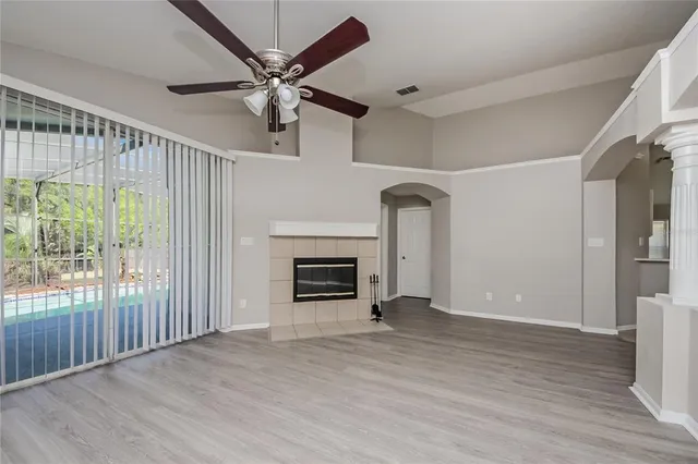 wooden floor fireplace and windows in an empty room