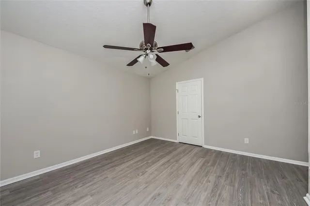 a view of room with hardwood floor and a ceiling fan