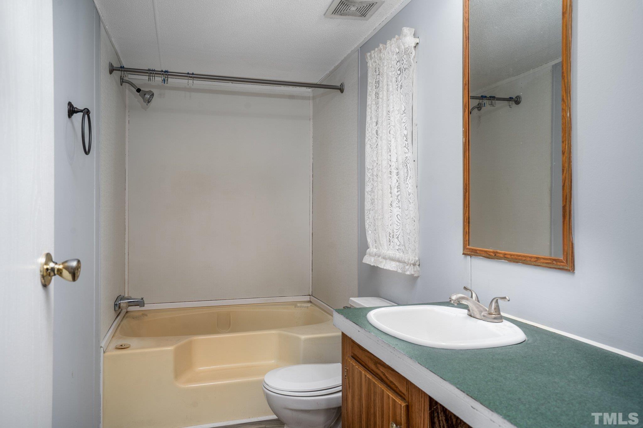 10014 Lake Royale Rd Spring Spring Hope, NC 27882 - Photo 17 of 26 a bathroom with a sink a toilet a shower curtain and a bath tub