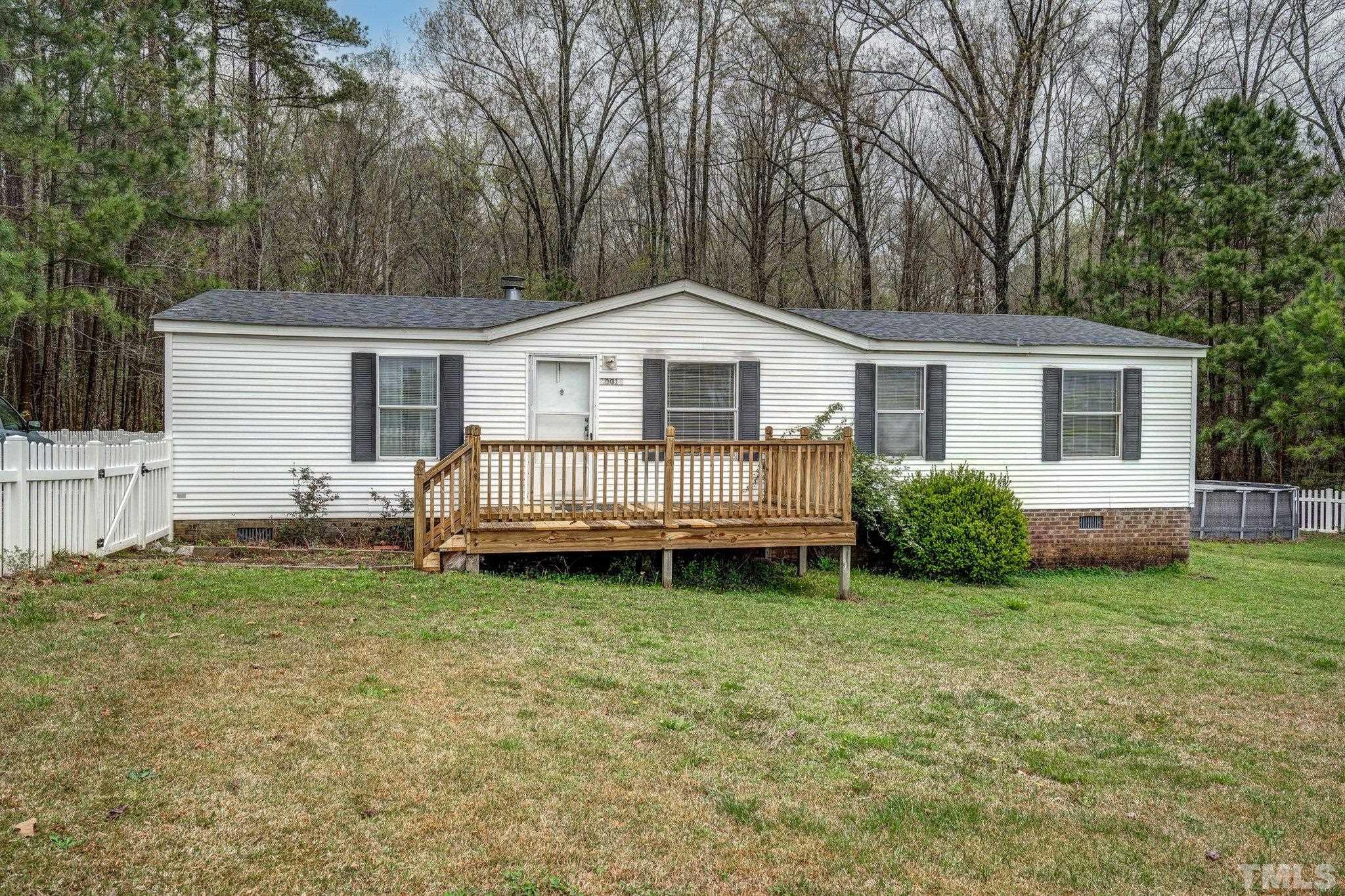 10014 Lake Royale Rd Spring Spring Hope, NC 27882 - Photo 2 of 26 a white house that has a small yard and large trees with wooden fence