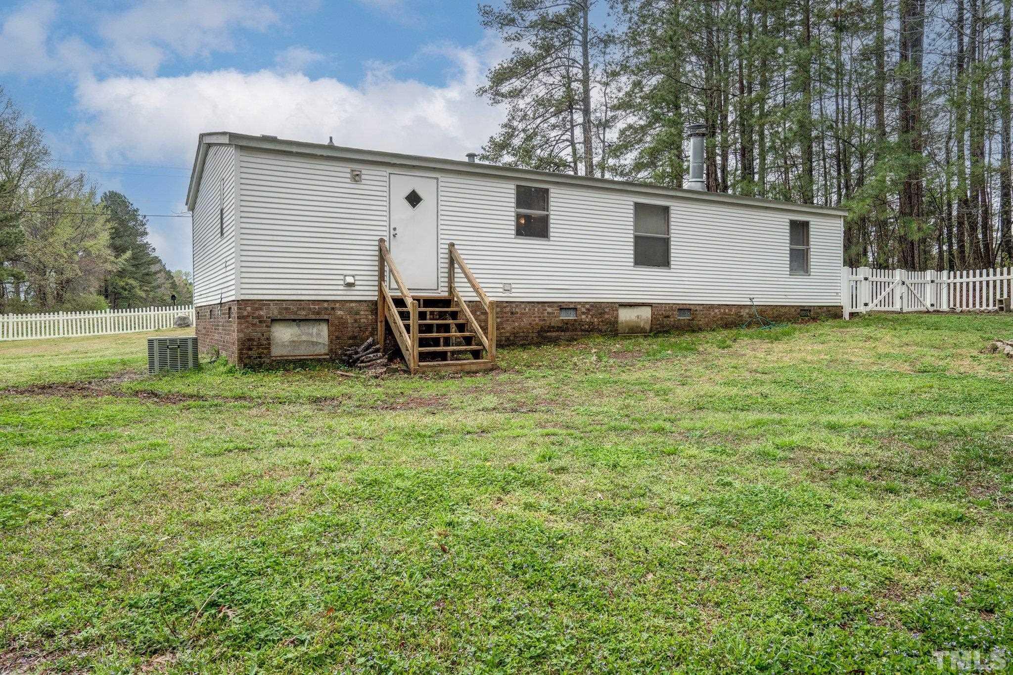 10014 Lake Royale Rd Spring Spring Hope, NC 27882 - Photo 25 of 26 a view of a backyard with table and chairs and wooden fence