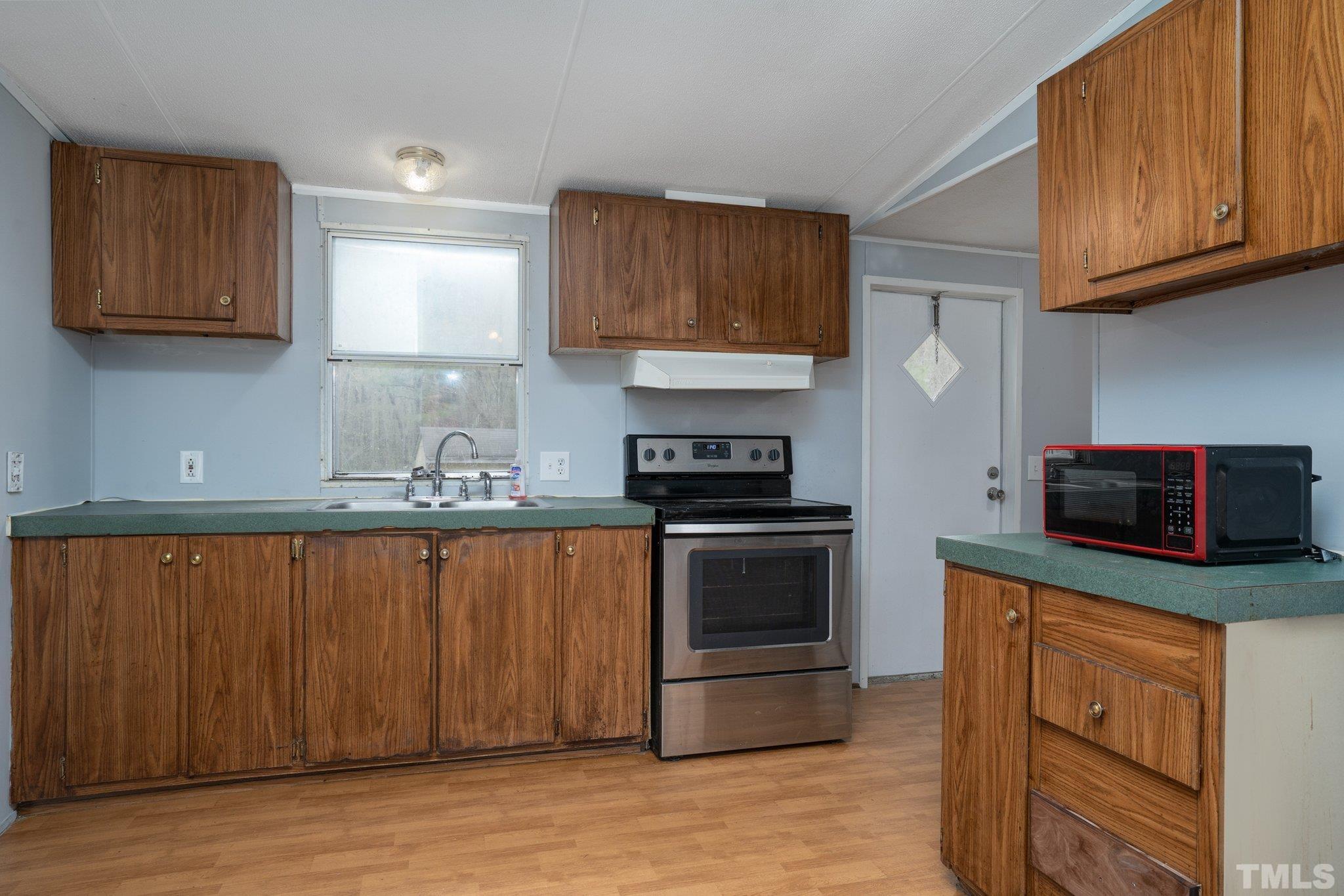 10014 Lake Royale Rd Spring Spring Hope, NC 27882 - Photo 10 of 26 a kitchen with stainless steel appliances granite countertop a stove a sink and a microwave