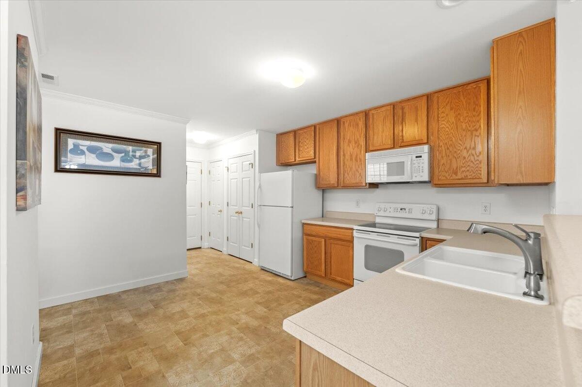 2621 Hamlet Green Drive Raleigh, NC 27614 - Photo 12 of 20 a kitchen with a stove a sink and a refrigerator