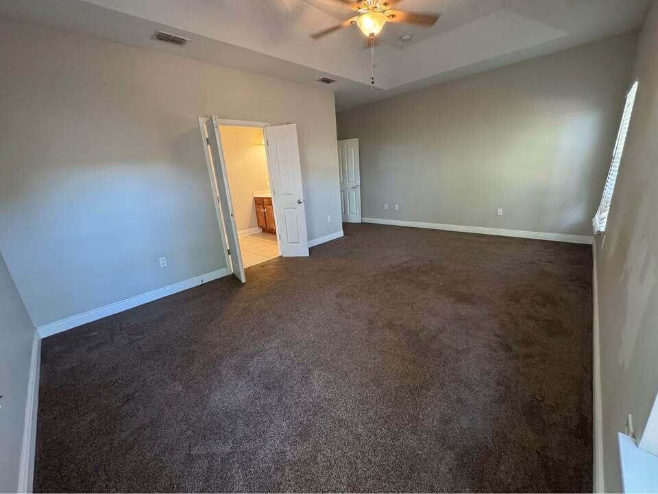 371 Symphony Way Freeport, FL 32439 - Photo 14 of 26 an empty room with a chandelier fan and windows