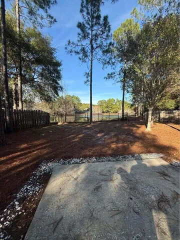 a view of a yard with wooden fence