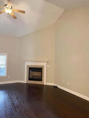a view of empty room with wooden floor and fireplace