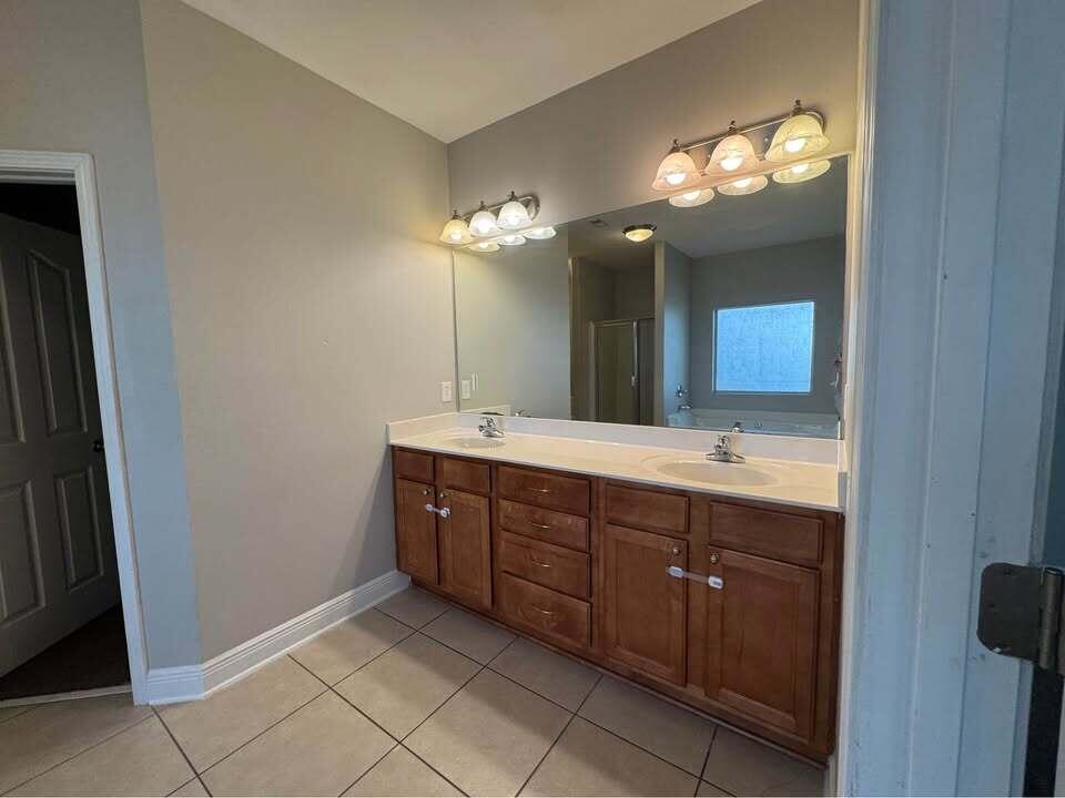 371 Symphony Way Freeport, FL 32439 - Photo 8 of 26 a spacious bathroom with a double vanity and a mirror