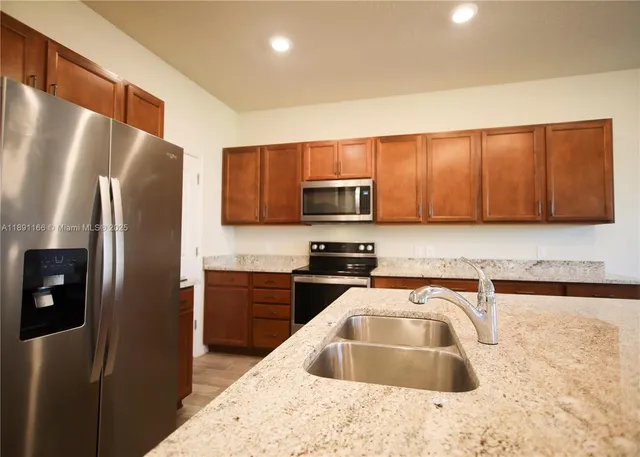 a metallic refrigerator freezer sitting in a kitchen