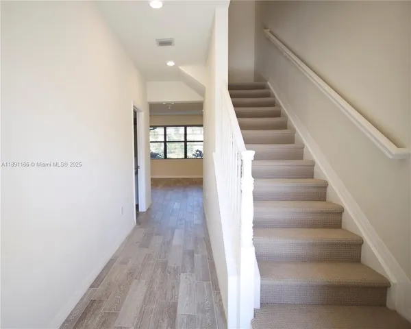 a view of entryway and hall with wooden floor