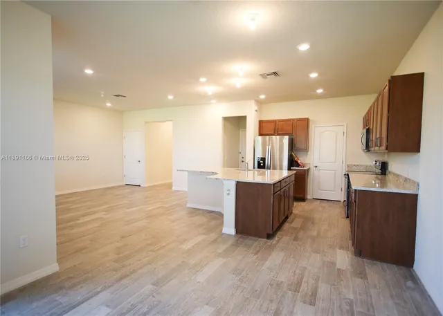 a kitchen with a sink a refrigerator and a stove top oven