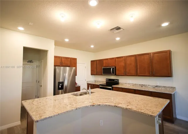 a kitchen with granite countertop cabinets stainless steel appliances and wooden cabinets