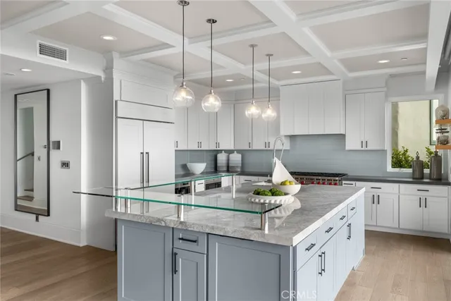 a large white kitchen with a large window and table