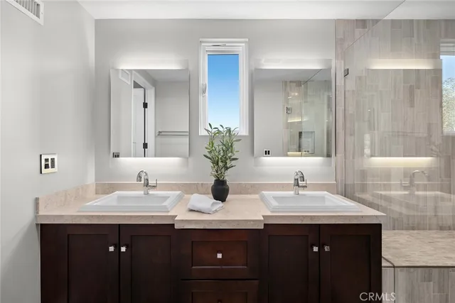 a bathroom with double sink and a mirror