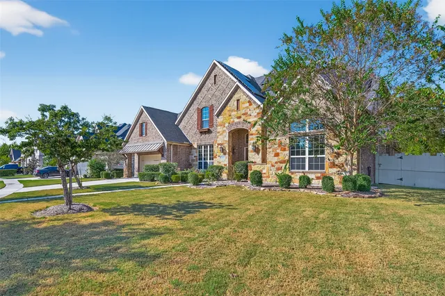 a view of a big house with a big yard and large trees